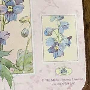 May include: A pink and white floral design with a blue flower in the center. The text "The Medici Society Limited, London NW9 6JZ" is printed at the bottom.