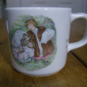 Puede incluir: Taza de cerámica blanca con una ilustración colorida de dos personajes del libro infantil "La historia de la señora Tiggy-Winkle" de Beatrix Potter. La taza tiene un asa y el texto "Mrs. Tiggy-Winkle" está impreso en el lateral.