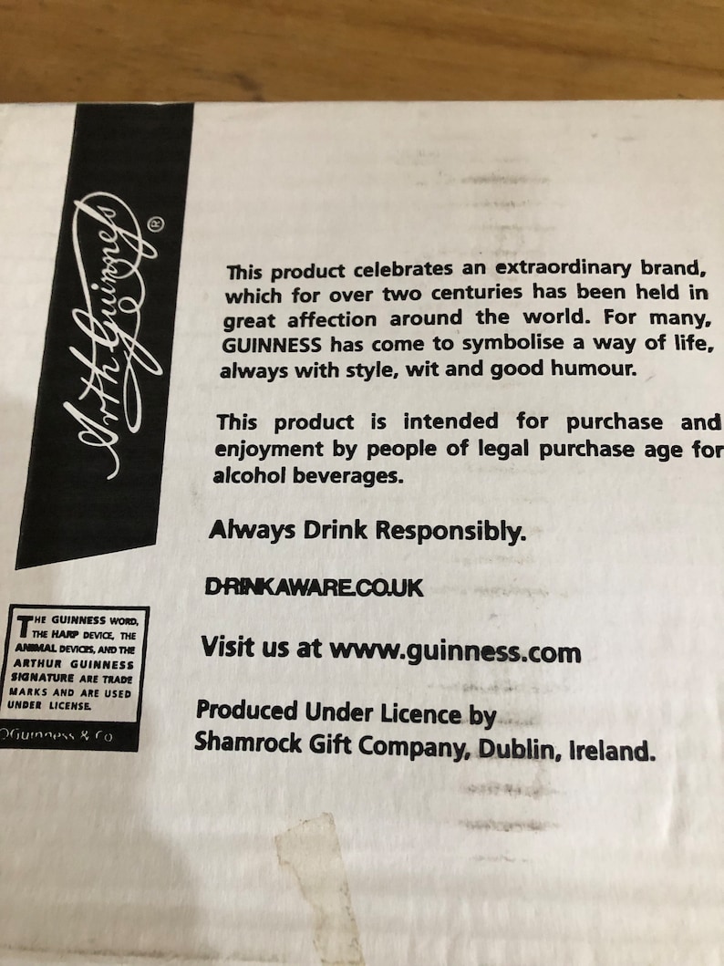 May include: A white box with black text that reads "This product celebrates an extraordinary brand, which for over two centuries has been held in great affection around the world. For many, GUINNESS has come to symbolise a way of life, always with style, wit and good humour. This product is intended for purchase and enjoyment by people of legal purchase age for alcohol beverages. Always Drink Responsibly. DRINKAWARE.CO.UK Visit us at www.guinness.com Produced Under Licence by Shamrock Gift Company, Dublin, Ireland."