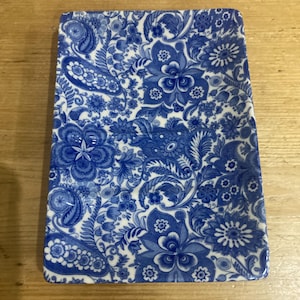 Puede incluir: Plato rectangular de cerámica con un estampado floral azul y blanco. El diseño presenta flores estilizadas, hojas y elementos de cachemira. El plato se utiliza probablemente para servir o exhibir.