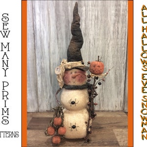 May include: A handmade Halloween snowman doll with a witch's hat, a pumpkin, and spiders. The snowman is made of white fabric and has a stitched face. The doll is standing on a wooden surface. "ALL HALLOWS EVE SNOWMAN" is written on the right side of the image.