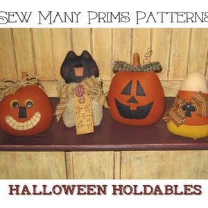 May include: Four Halloween-themed felt decorations: a black cat, a jack-o'-lantern, a pumpkin with a smiling face, and a candy corn. The decorations are arranged on a wooden shelf. The cat is holding a tag that says "Trick or Treat".
