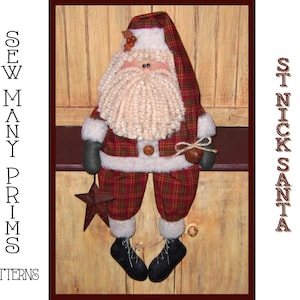 May include: A handmade St. Nick Santa doll with a plaid red and green outfit, a white beard, and a star-shaped ornament. The doll has black boots and a matching plaid hat. The text "Sew Many Prims Patterns" is on the left.