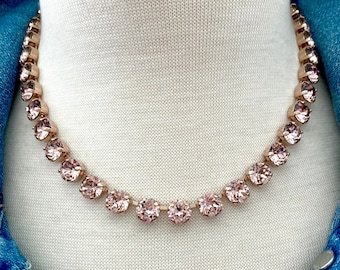 May include: A rose gold necklace with a delicate chain and pink crystal stones.