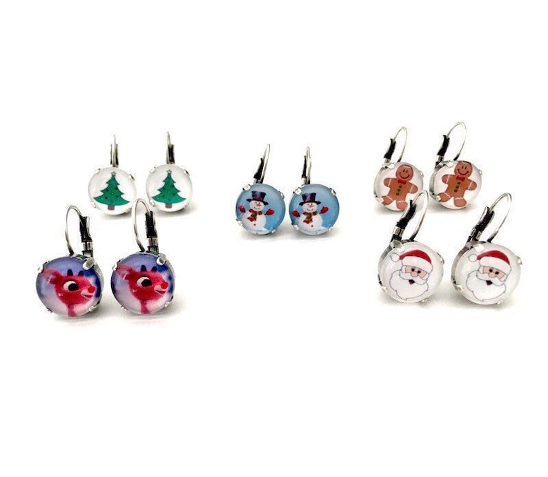 May include: Assortment of Christmas themed earrings.  The earrings are silver with a clear glass cabochon.  The designs include a Christmas tree, a snowman, a gingerbread man, Santa Claus, and a reindeer.