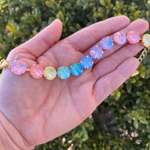 Peut inclure: Un bracelet en cristal arc-en-ciel avec des accents dor&eacute;s. Le bracelet pr&eacute;sente des cristaux ronds et iris&eacute;s dans des tons de rose, jaune, bleu et violet.