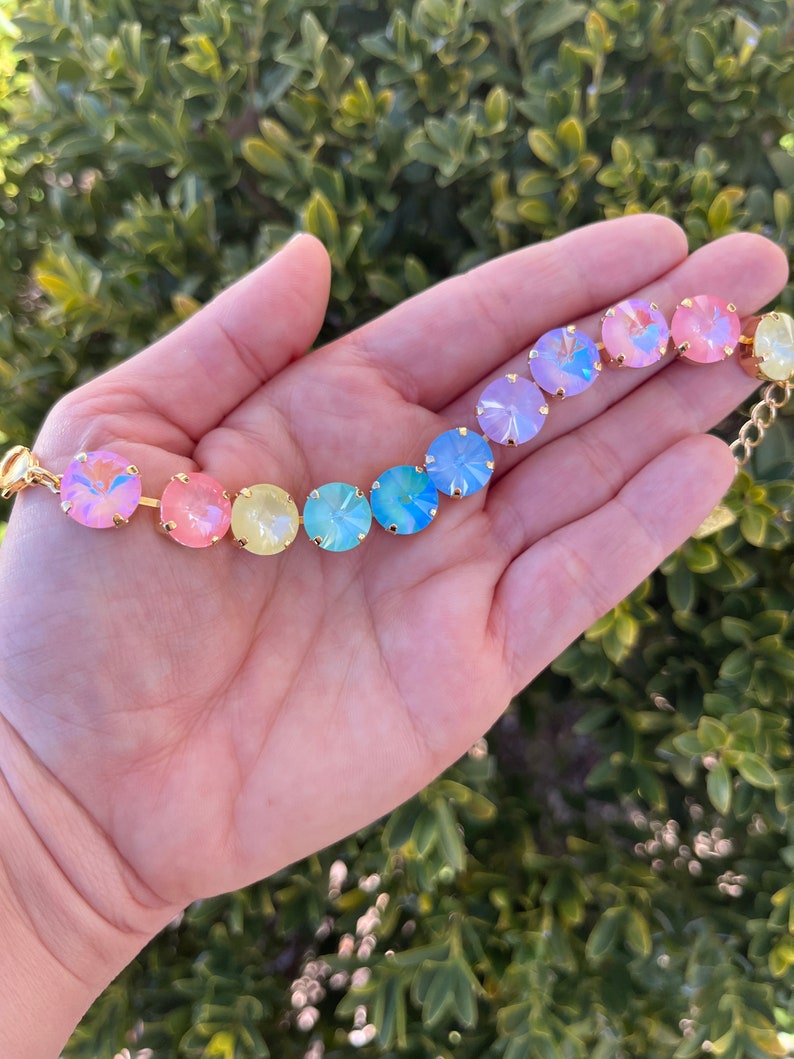 Peut inclure: Un bracelet en cristal arc-en-ciel avec des accents dor&eacute;s. Le bracelet pr&eacute;sente des cristaux ronds et iris&eacute;s dans des tons de rose, jaune, bleu et violet.