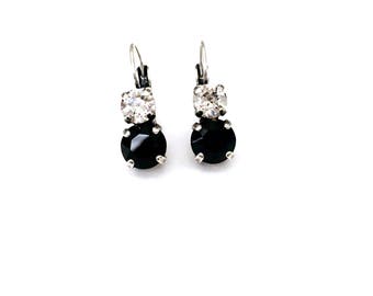 May include: A pair of silver dangle earrings with a black and white crystal design.