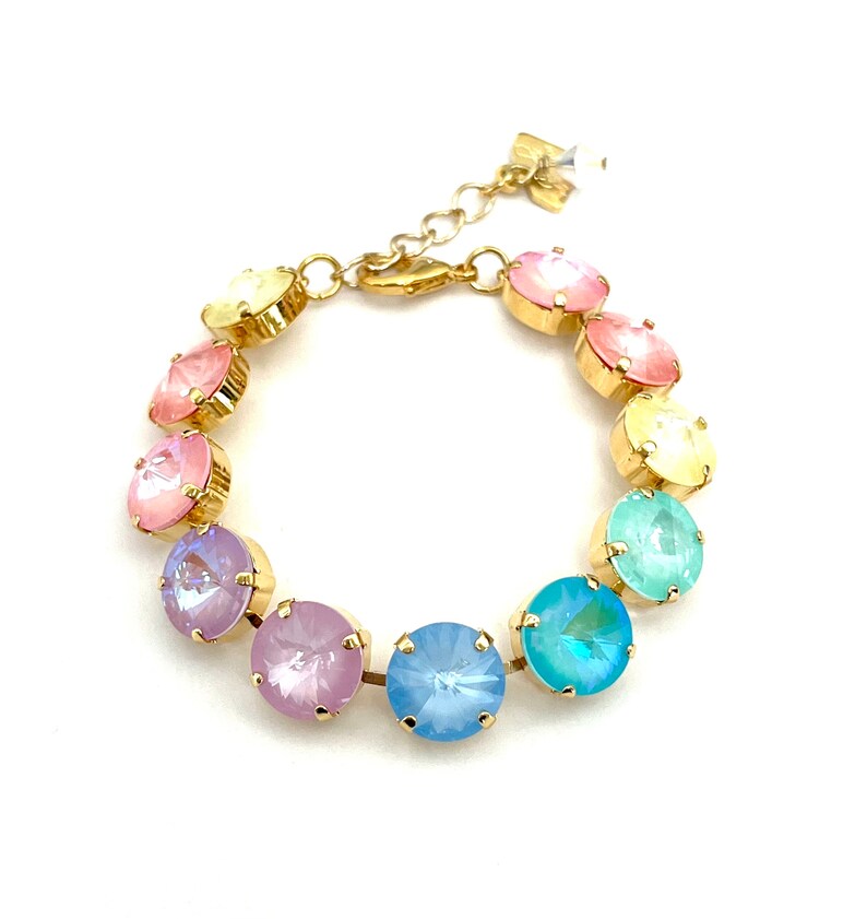 Peut inclure: Un bracelet en or avec des pierres de cristal de couleur pastel arc-en-ciel. Le bracelet a une fermeture &agrave; fermoir.
