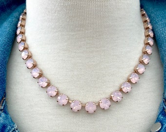 May include: A rose gold necklace with a row of pale pink opal stones.