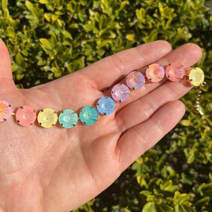 Peut inclure: Un bracelet en cristal arc-en-ciel avec des pierres rondes et iris&eacute;es. Le bracelet est en m&eacute;tal dor&eacute; et se ferme avec un fermoir.