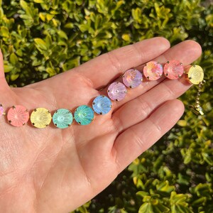 Peut inclure: Un bracelet en cristal arc-en-ciel avec des accents dor&eacute;s. Le bracelet pr&eacute;sente des cristaux ronds et iris&eacute;s dans des tons de rose, jaune, vert et bleu.