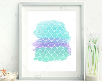 Puede incluir: Una impresión enmarcada con un diseño de acuarela de escamas de sirena de color turquesa y morado. La impresión está en un marco blanco y está colgada en una pared blanca.