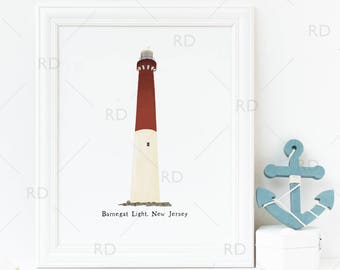 May include: A white framed print of a red and white lighthouse with the text "Barnegat Light. New Jersey". A blue wooden anchor is on a white surface to the right of the print.