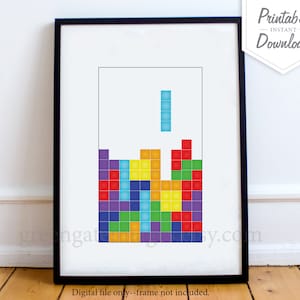 Peut inclure: Un t&eacute;l&eacute;chargement num&eacute;rique imprimable d'une estampe d'art inspir&eacute;e d'un jeu vid&eacute;o r&eacute;tro avec un motif de blocs Tetris color&eacute;s. L'impression est encadr&eacute;e dans un cadre noir et porte le texte "Fichier num&eacute;rique uniquement - cadre non inclus."