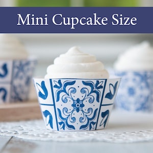 May include: Mini cupcake liners with a blue and white floral design, filled with white frosting. The liners are displayed on a white doily. The text "Mini Cupcake Size" is displayed in a blue banner above the cupcakes.