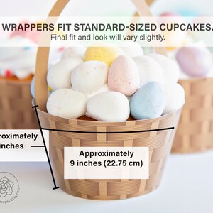May include: A set of two brown and white basket-style cupcake wrappers. The wrappers are approximately 1.75 inches tall and 9 inches in diameter. The text "WRAPPERS FIT STANDARD-SIZED CUPCAKES. Final fit and look will vary slightly." is printed on the image.