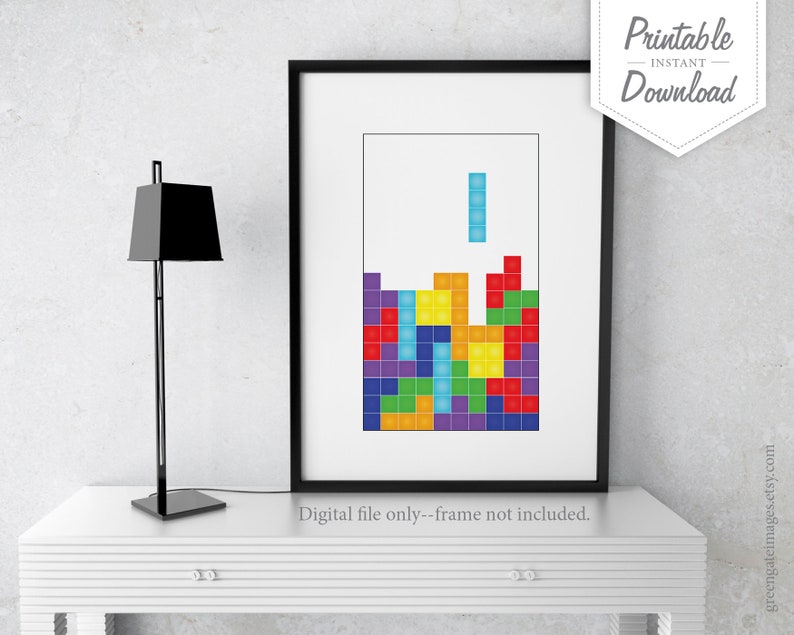 Peut inclure: Impression num&eacute;rique imprimable d'un jeu de Tetris en cours. Le jeu est compos&eacute; de blocs color&eacute;s dans des tons de rouge, orange, jaune, vert, bleu, violet et turquoise. L'impression est encadr&eacute;e dans un cadre noir et est affich&eacute;e sur une table blanche.