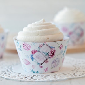 May include: White cupcake with a floral and book design cupcake wrapper. The cupcake has white frosting and is sitting on a white doily.