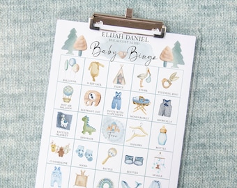 May include: A baby shower bingo card with illustrations of baby items, such as a hot air balloon, a knitted blanket, a rattle, and a pair of booties. The card has the text "Elijah Daniel Due August 14, 2021 Baby Bingo" at the top.