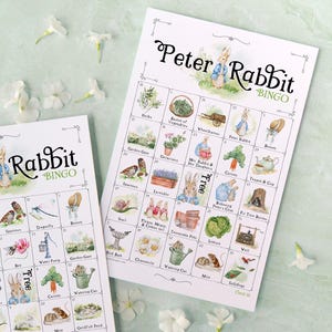 May include: A set of three ceramic mugs with a speckled, cream-colored glaze. Each mug features a different hand-painted floral design in shades of blue, green, and yellow. The mugs have a simple, rounded shape and a comfortable handle.