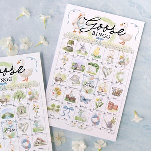 May include: Two "Goose Bingo" game cards with watercolor illustrations of farm-themed images, including a goose, well, and windmill. The cards are white with a light blue background and scattered white flowers.