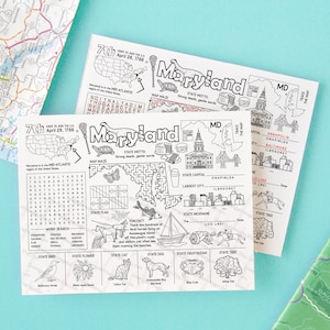 May include: Two black and white Maryland state activity sheets with illustrations and text, including a map maze, state symbols, and the text "Maryland". The sheets are on a light blue surface, with a map in the background.