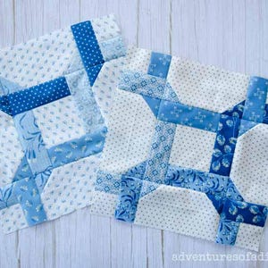 May include: Two blue and white patchwork quilt blocks with a geometric design. The blocks are made with different blue fabrics with white polka dots, floral patterns, and solid blue.