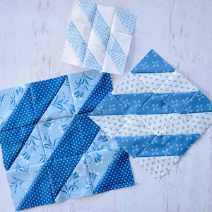May include: Three handmade quilt blocks in shades of blue and white. The blocks feature various geometric patterns, including stripes, triangles, and floral prints. The fabrics are arranged in a patchwork style, showcasing the artistry of quilting.