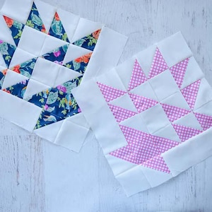 Puede incluir: Dos bloques de patchwork con diseños de cestas. Uno presenta triángulos de tela floral azul, el otro triángulos rosas estampados. Ambos bloques tienen tela blanca y están sobre una superficie de madera blanca.