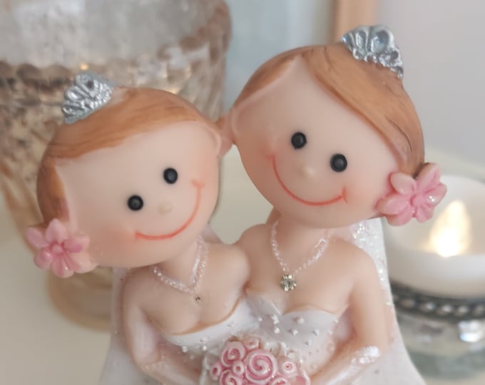 Wedding CAKE topper BRIDE & BRIDE cartoon female couple in wedding dresses just married on the dress both holding a pink rose bouquest
