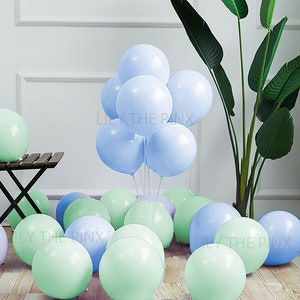 Puede incluir: Un grupo de globos de color azul claro y verde. Los globos de color azul claro están agrupados en el centro de la imagen, mientras que los globos verdes están dispersos en la parte inferior de la imagen.