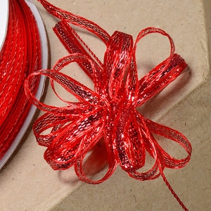 May include: Red metallic ribbon with a bow tied in the center. The ribbon is shiny and has a textured surface.