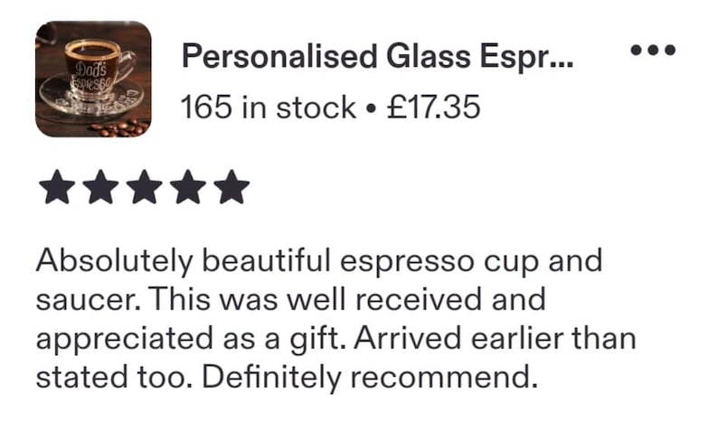 May include: A clear glass espresso cup and matching saucer set. The cup features white etched text that reads "Dad's Espresso" on the front. The set is filled with dark brown coffee and is positioned on a dark surface with scattered coffee beans.