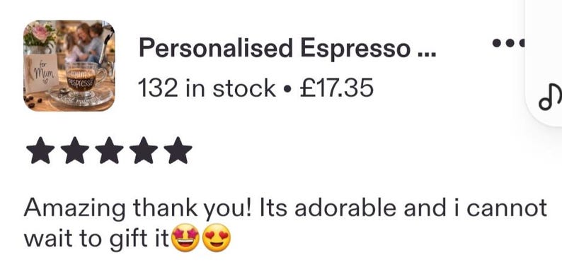 May include: A clear glass espresso cup featuring the word espresso in black cursive script, resting on a matching glass saucer. Next to the cup is a small wooden sign with the text for Mum and a small heart symbol, with a blurred background.