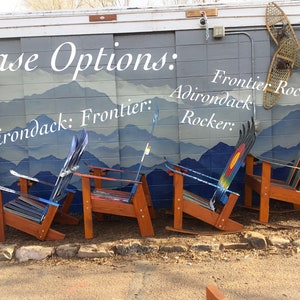 May include: Four wooden Adirondack chairs with different ski designs. The chairs are labeled "Adirondack", "Frontier", "Adirondack Rocker", and "Frontier Rocker".