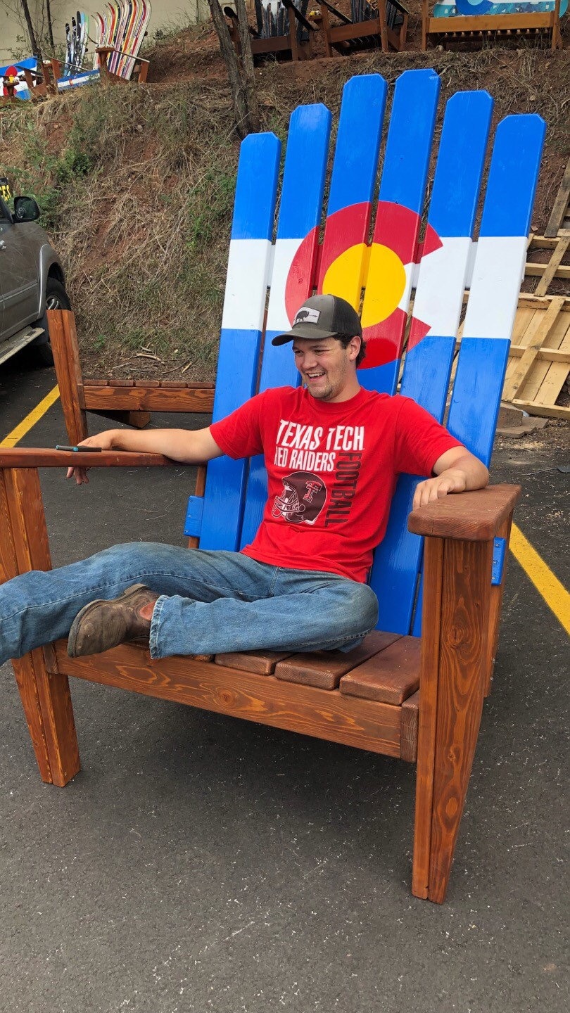 Man Sitting in Giant Adirondack Chair Stock Photo