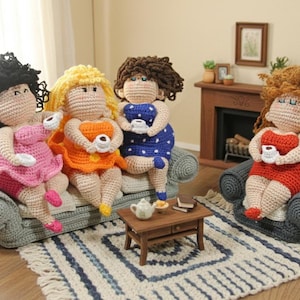 Op de afbeelding: Gehaakte poppen in roze, oranje, blauwe en rode jurken zitten op een grijze bank en fauteuil. Elke pop houdt een klein wit kopje vast. Voor de bank staat een kleine houten tafel met een theepot en boeken.