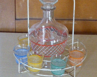 Liquor service consisting of a metal servant, a carafe and 6 small checkered glasses in vintage color 1950