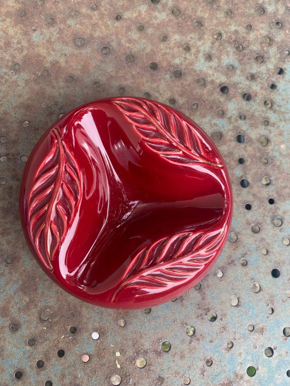 Ashtray in ceramic enameled burgundy red with a decor of leaves in relief, signed Verceram and numbered: 4810.