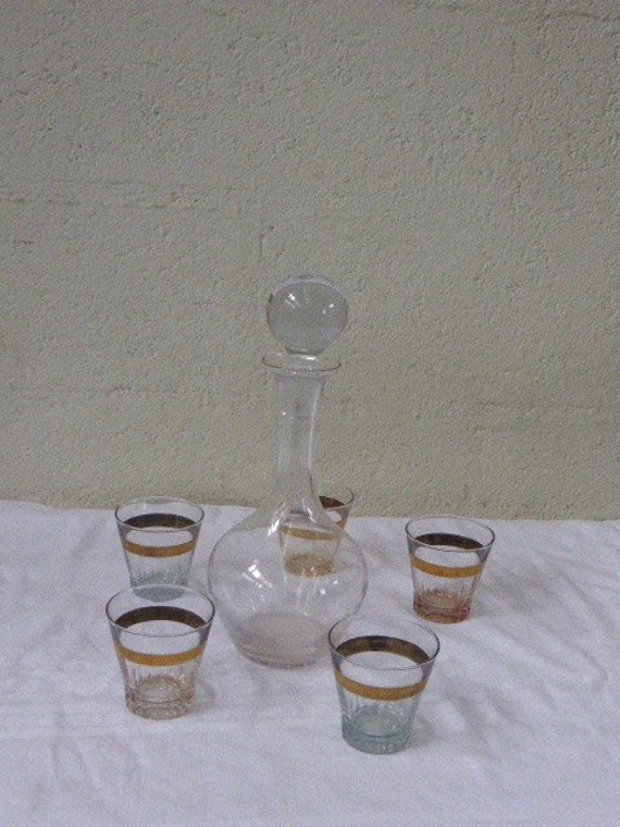 Service consisting of a glass carafe and 5 glasses vintage aperitif 1950, gold edging and each background has a different color