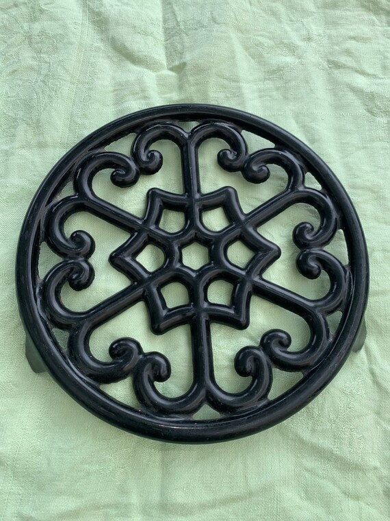 Geometric pattern trivet in vintage black enameled cast iron