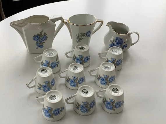 White porcelain coffee service with blue roses motif composed of 9 cups and 3 milk and water jugs, art deco, stamped BP France