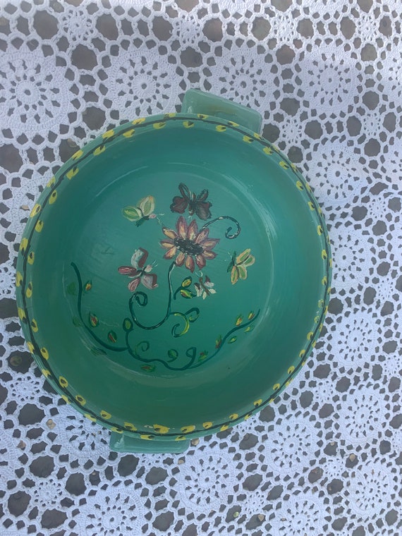 Small decorative metal pan painted in glass with a floral pattern on the old background