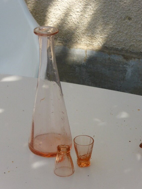 Pink glass liqueur service, composed of a bottle decanter and two small vintage glasses 1940