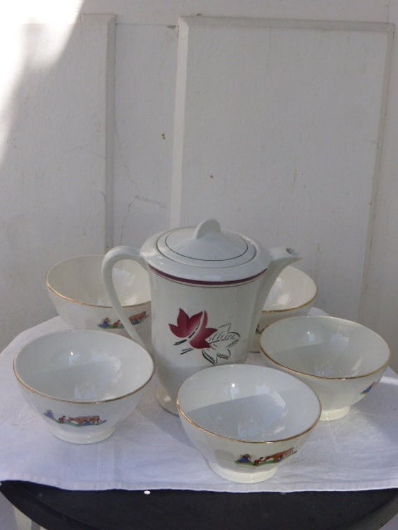 Coffee service consisting of a white earthenware coffee pot with red leaves and 5 bowls faceted white faience with a decor