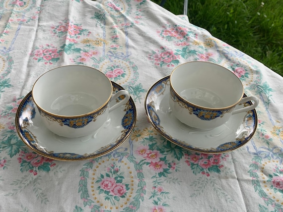 Two art deco porcelain tea cups and saucers, PP Limoges France stamp, white porcelain decorated with fruit baskets