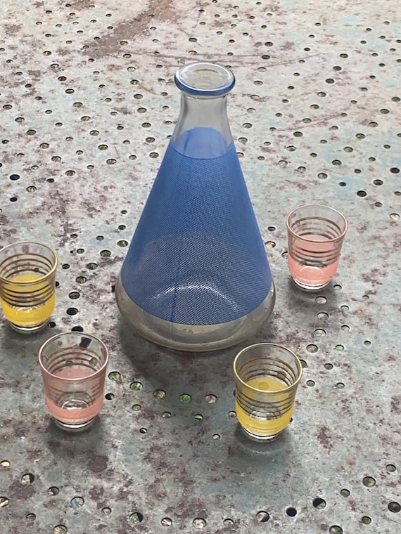 Liqueur set consisting of a blue screen-printed glass carafe and four small pink and gold granite glasses with gold trim, vintage 1960s