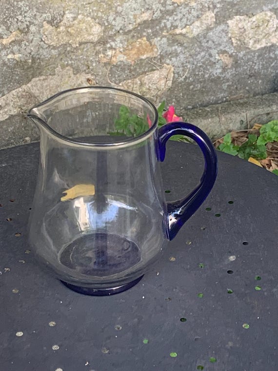 PICHET CARAFE in transparent glass with handle and vintage blue background