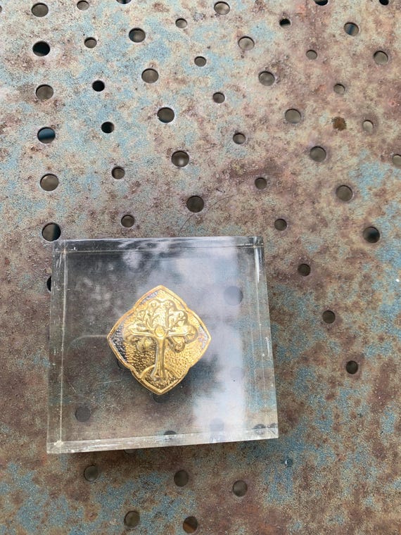 Plexiglas paperweight with a vintage gold tree of life medallion.